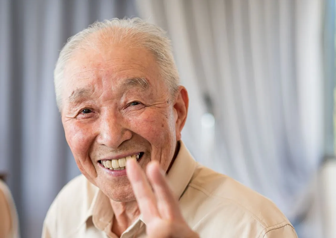 笑顔で手を振るシニアの男性