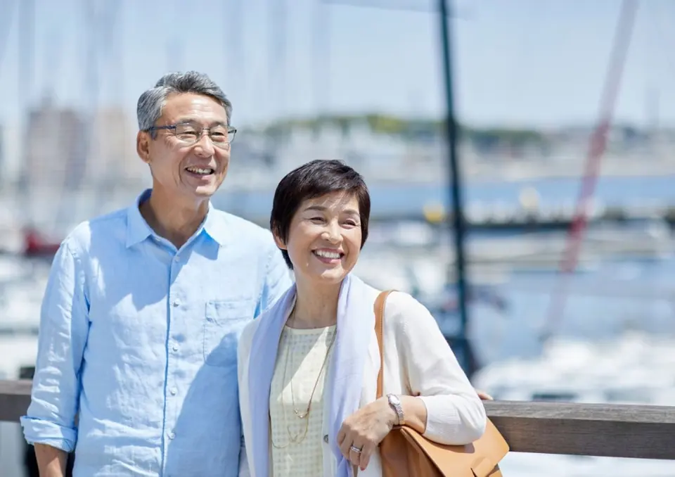 海辺でほほえむシニアのご夫婦